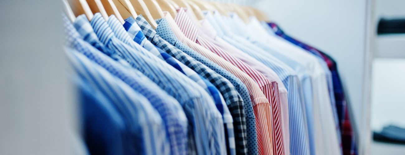 Close-up photo of fashionable clothes on hangers in the shop.